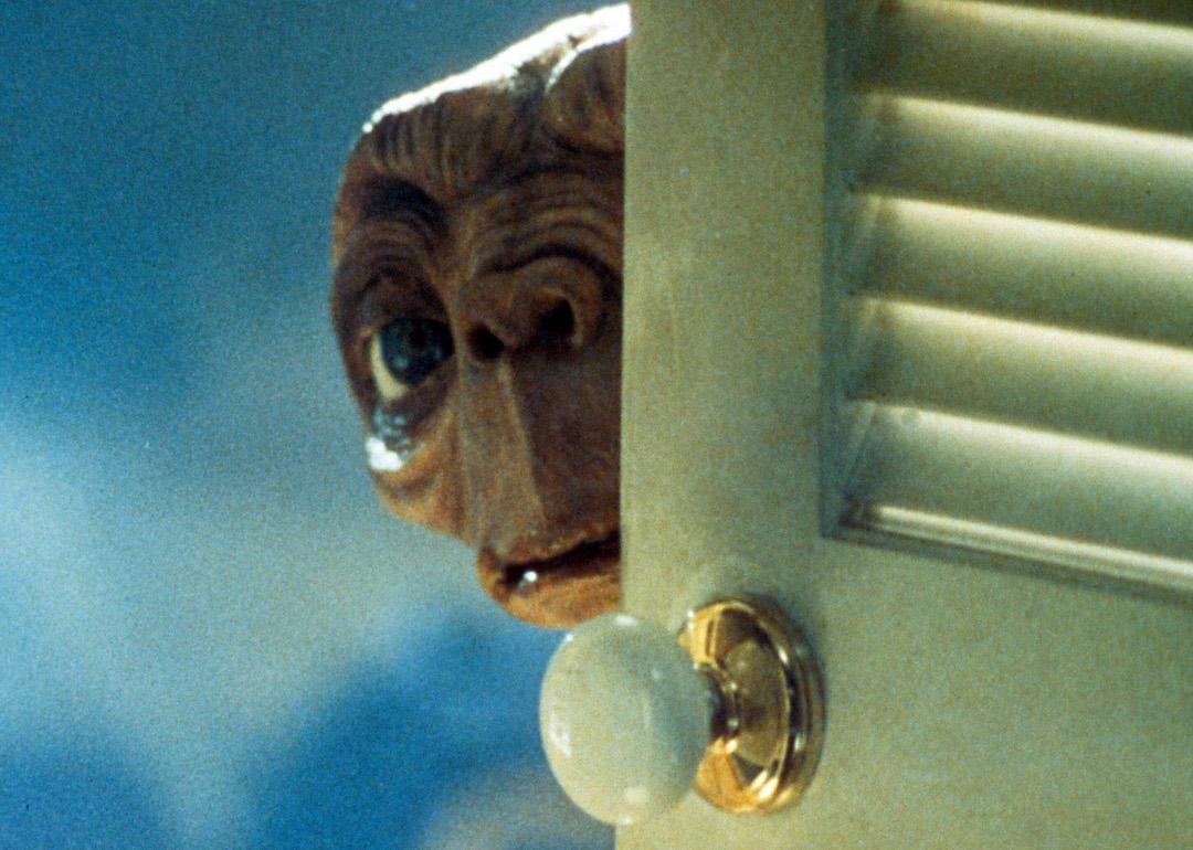 E.T. peers from behind a door in a scene from the film 'E.T. The Extra-Terrestrial.'