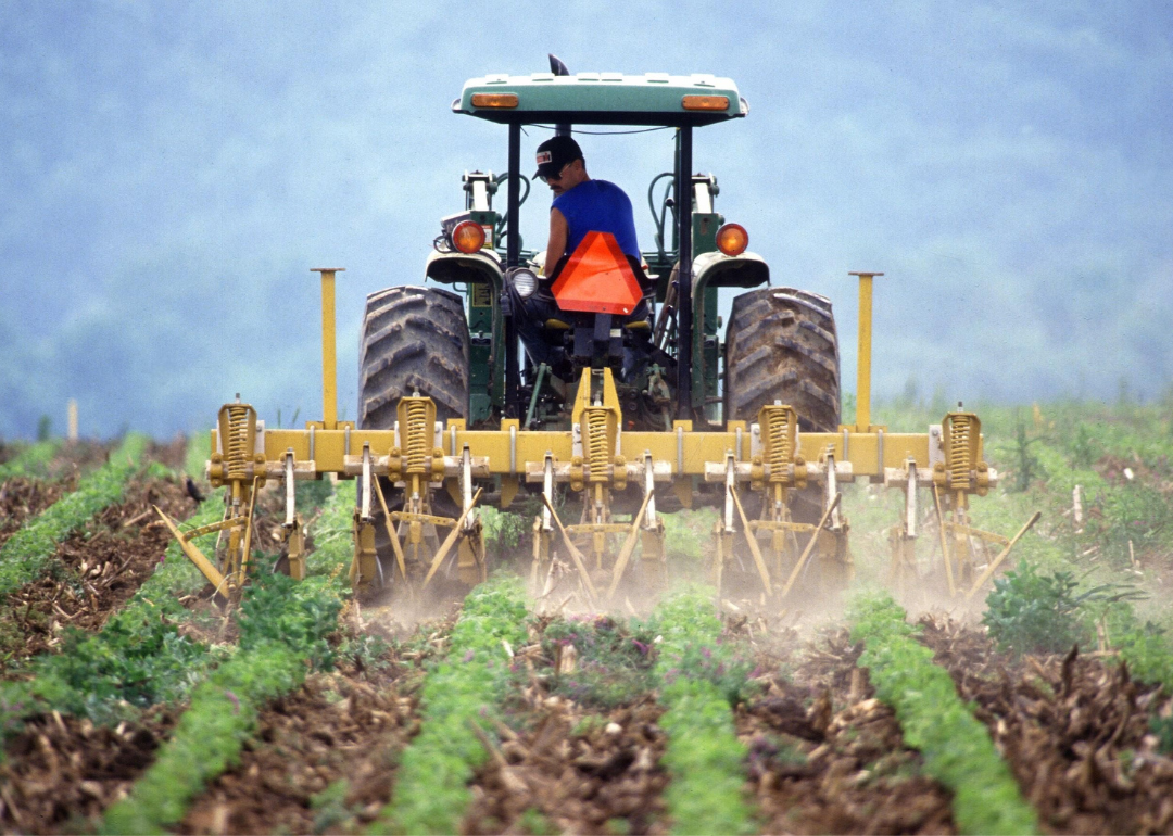 A farmer on a tractor working in the field.