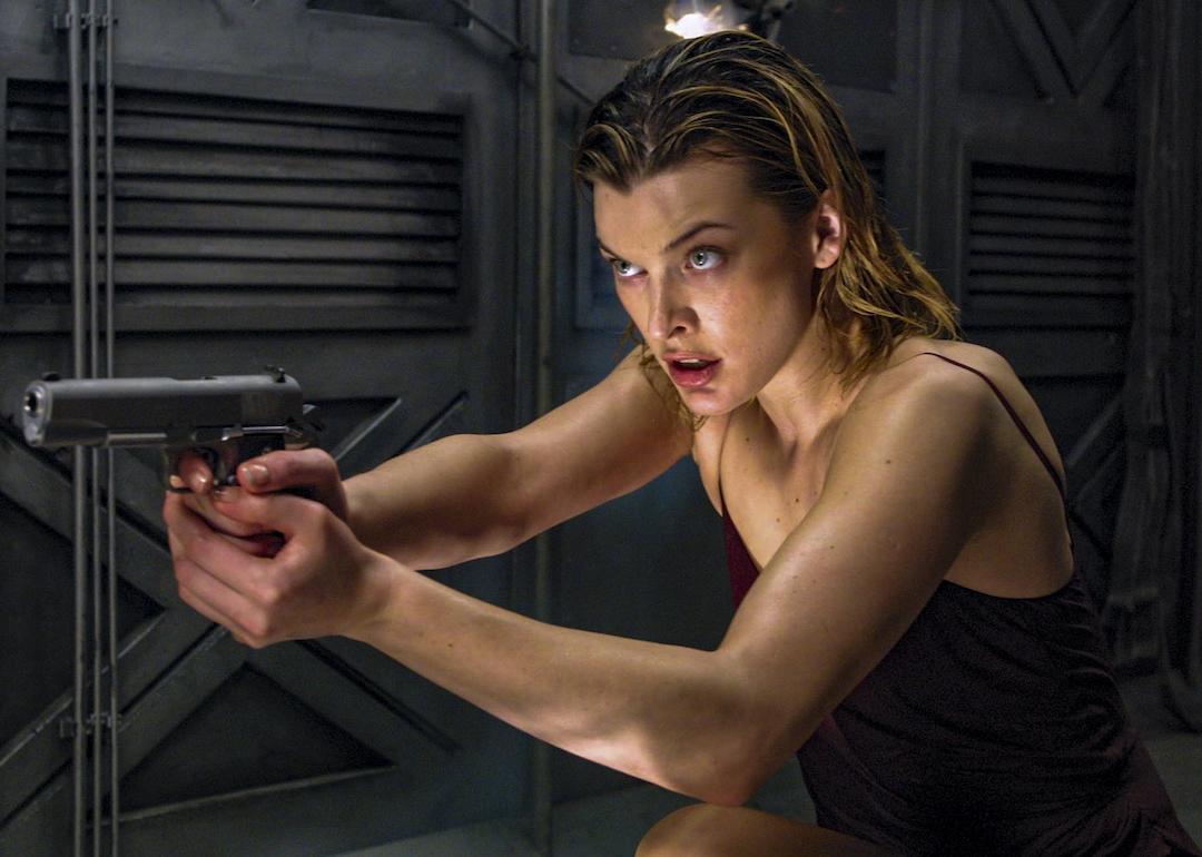 Actor Milla Jovovich holding a gun in the zombie movie 'Resident Evil.'