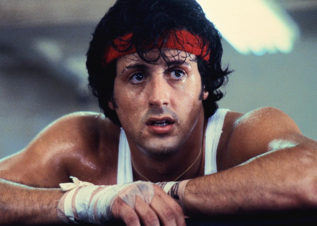 Sylvester Stallone wears a red sweat band and white tank top on the set of his movie 'Rocky II.'