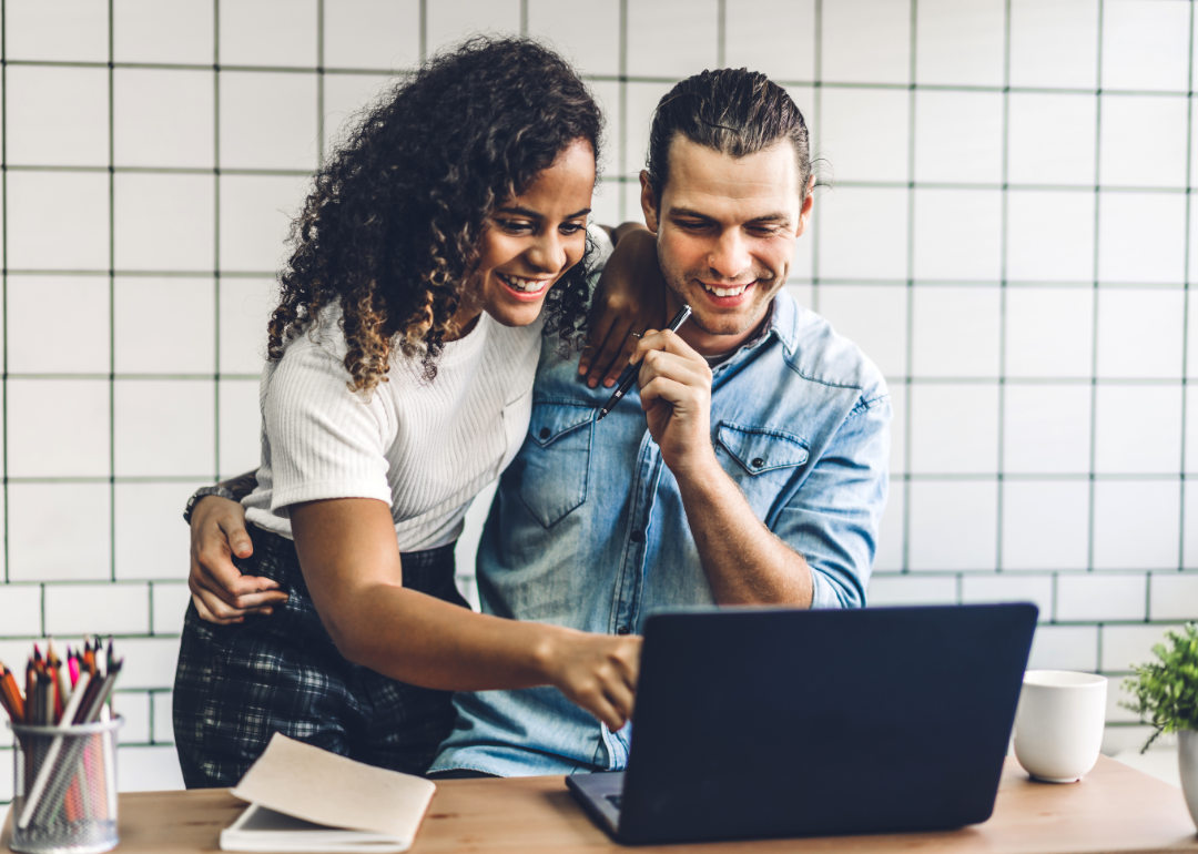 Happy couple at looking at laptop together.