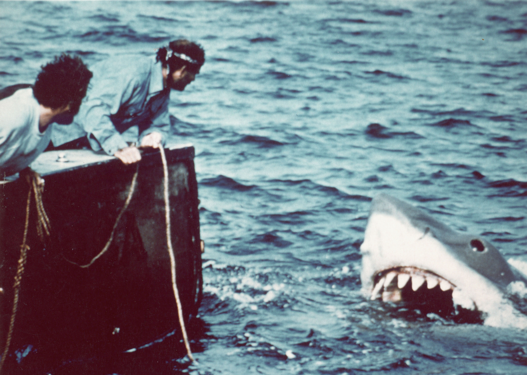 Actors Richard Dreyfuss (left) and Robert Shaw (right) look off the stern of a fishing boat at the terrifying approach of the giant shark in a scene from "Jaws"