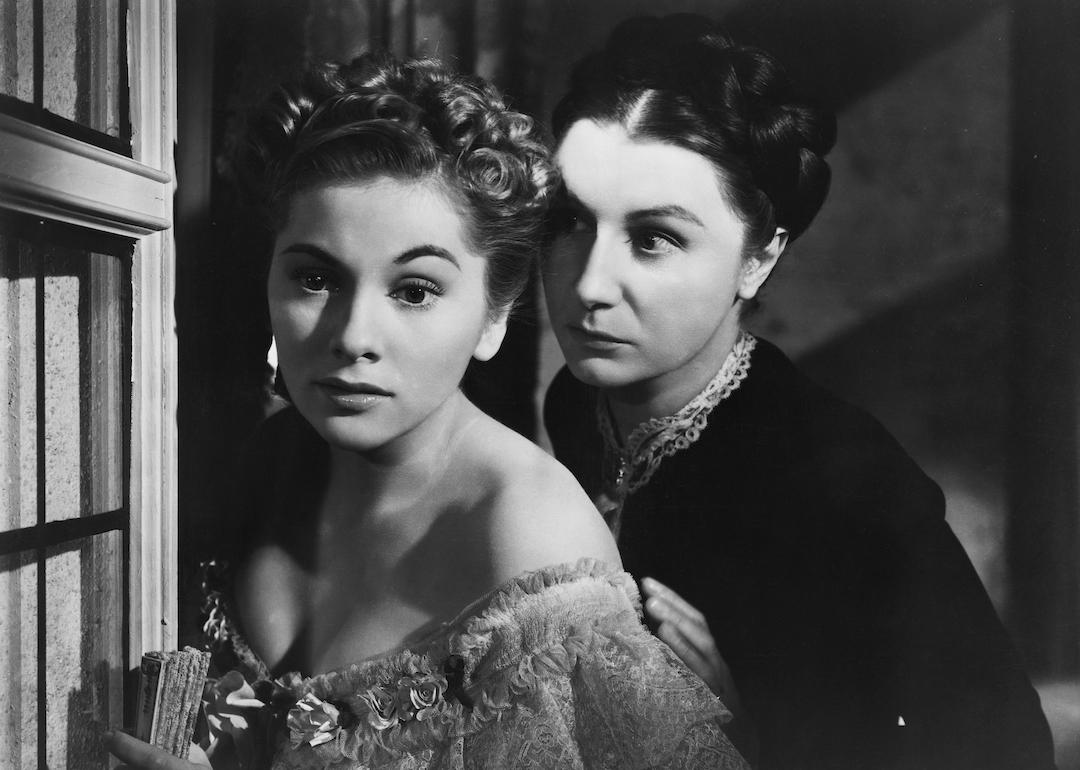Actors Joan Fontaine and Judith Anderson look out of a window in the 1940 thriller 'Rebecca.'