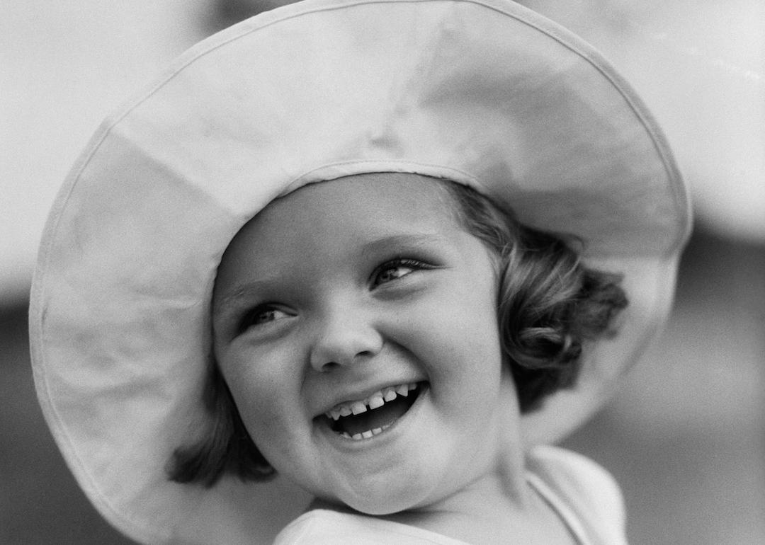 Toddler in the 1930s wearing a wide-brimmed hat and smiling.