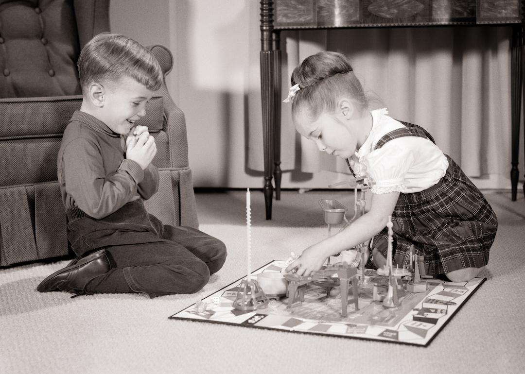 Siblings in the '60s playing the board game Mouse Trap on their living room floor.
