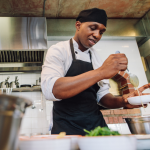 Chef mixes sauces in restaurant kitchen.