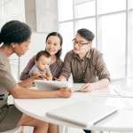 A young family sits at a table working with a financial consultant