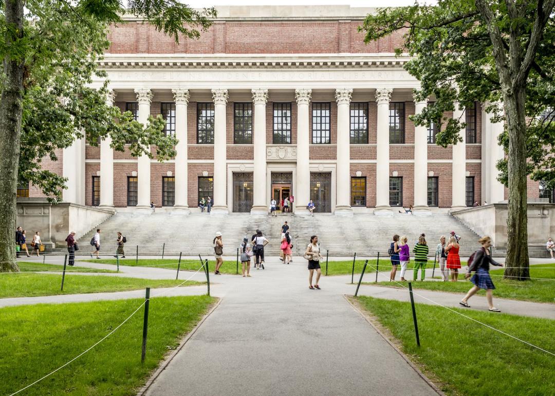 View of the campus of the famous Harvard University in Cambridge, Massachusetts, with some students, locals, and tourists passing by.
