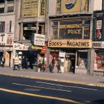 View of book stores, employment agencies, and beauty supply shops line 42nd Street in Manhattan's Times Square in New York, New York in the 1970s.