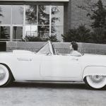 Person sits in their Ford Thunderbird convertible with the top down in the 1950s.