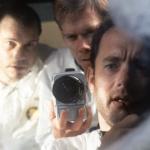 Bill Paxton, Kevin Bacon, and Tom Hanks looking out ship window in a scene from the 1995 film 'Apollo 13.'
