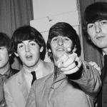 Ringo Starr points at the camera as fellow Beatles, John Lennon, Paul McCartney, and George Harrison, stand beside him backstage at a charity performance at the Paramount Theater in New York City.