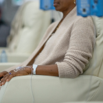 Person sitting in chair and receiving chemotherapy treatment 