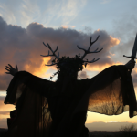 A man representing the Winter King holds a sword as he takes part in a sunset ceremony as they celebrate the Samhain old pagan festival.
