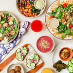 An overhead view of a variety of plant-based foods on a white surface.