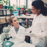 Two women scientists discuss their findings in a laboratory environment