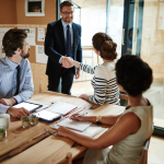 Two people shake hands at a business meeting