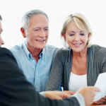 A older couple sit with a financial advisor and go over some paperwork