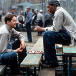 Tim Robbins and Morgan Freeman sitting outside on the benches playing checkers and talking in a scene from the film 'The Shawshank Redemption', 1994. 