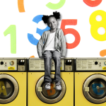 A young girl sits atop a row of washing machines