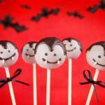 Vampire cake pops on a red background with bats.