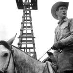 Actor Paul Newman wearing a cowboy hat and riding a horse in the 1963 movie 'Hud.'