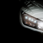 Close-up of a luxury sedan's headlights against a black background