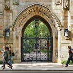 Students pass by a decorative stone archway at the entrance to Yale University in New Haven, Connecticut.