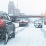 Cars moving slowly on a snow-covered highway