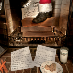 Santa's feet emerging from a chimney with a letter to Santa and cookies in the foreground
