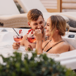 A couple sipping drinks in a hot tub