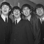 Paul McCartney, Ringo Starr, George Harrison, and John Lennon of The Beatles smiling in London in 1964.