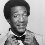 Promotional studio portrait of actor and comedian Bill Cosby adjusting his bow tie from his 1969 television series 'The Bill Cosby Show'.