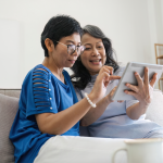 two senior friends use a tablet together