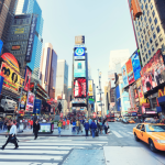 Times Square in New York City, with lit-up billboards and people walking by