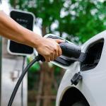 person plugging electric vehicle charger into car