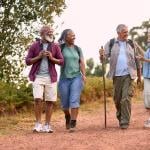 group of four seniors walking in the countryside