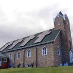 church with solar panels on roof in shape of cross