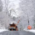 crews in bucket truck working on power lines in snowy condition