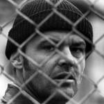 Actor Jack Nicholson looking through fence in a scene from the 1975 film 'One Flew Over The Cuckoo's Nest.'