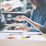 close up of people working, two women looking at computer