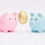 two piggy banks with golden egg symbolizing concept of combining two savings accounts