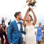 couple at wedding on the beach throwing bouquet