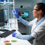 A biochemist looking at a fungi colony in a medical petri dish in a hospital laboratory. 