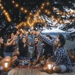 friends celebrating together outdoors on a picnic while darkness falls