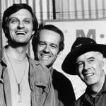 Actors Alan Alda, Mike Farrell, and Harry Morgan on the set of 'M*A*S*H' in 1975.