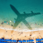 shadow of plane over tropical beach