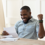 Excited person fist pumping the air while reading a letter