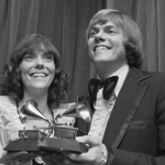 Singers Karen and Richard Carpenter of The Carpenters holding their Grammy awards, circa 1972