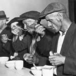 People eating bread and soup in a breadline during the Great Depression.